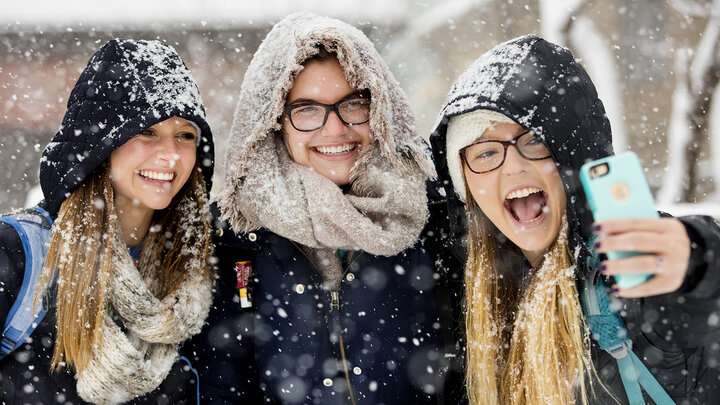 Kayla Felix (from left) and Alli Hauger smile as Emily Hames takes a selfie while they walked to class as snow fell on Jan. 25.
