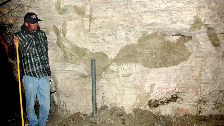 Shane Tucker, NU State Museum highway paleontologist, with the burrow image reconstructed as it would be exposed in the wall of the Happy Jack Chalk Mine.